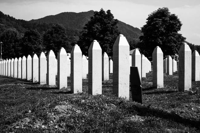 a black and white photo featuring a row of gravestones in a cemetery